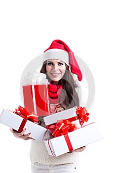 Christmas shopping woman holding many Christmas gifts in her arms wearing santa hat and winter clothing.