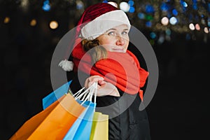 Christmas shopping of young beautiful woman. Colorful bright paper bags with gifts,presents.Walking on market street in city.