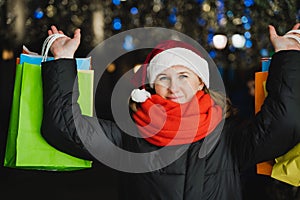 Christmas shopping of young beautiful woman. Colorful bright paper bags with gifts,presents.Walking on market street in city.