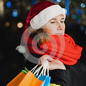 Christmas shopping of young beautiful woman. Colorful bright paper bags with gifts,presents.Walking on market street in city.