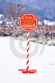 Christmas sign with text \'Santa Stop here\' in snow