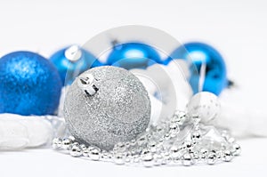 Christmas silver ball in focus and blue balls in background wi