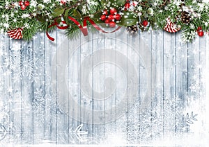 Christmas snow background with garland with candies, holly and branches