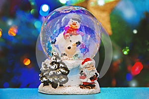 Christmas snow globe with Christmas tree lights background