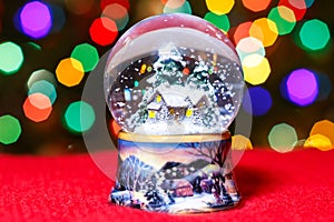 Christmas Snow Globe in front of Christmas tree lights closeup