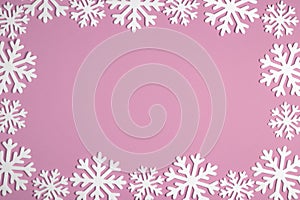 Christmas snowflake border frame on pink background. Xmas minimal texture with copy space. top view