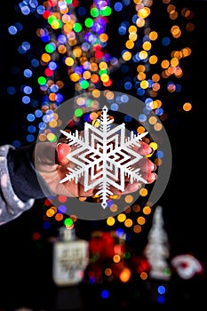 Christmas snowflake decoration isolated on background with blurred lights.