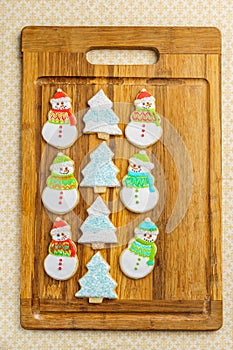 Christmas snowman and tree cookies on the cutting board winter selebration background.