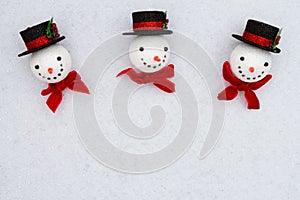 Christmas snowmen with top hats on white sparkle felt background