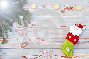 Christmas sock on wooden background. Toy and Christmas stocking, there is a branch of fir. Christmas and New Year decorations.