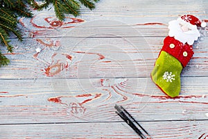 Christmas sock on wooden background. Toy and Christmas stocking, there is a branch of fir. Christmas and New Year decorations.