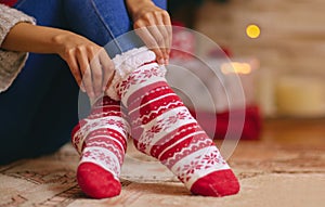 Christmas, socks and feet of person in home with cozy, comfortable and warmth for traditional festival. Winter, house
