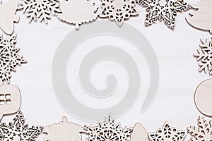 Christmas soft beige wooden snowflakes on a wood white background.