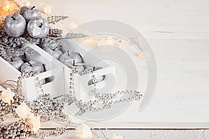 Christmas soft silver apples and lights burning in boxes on a wooden white background.