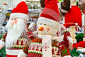 Christmas soft toy, snowman and Santa Claus. Santa Claus with a friend in the shop windshield.