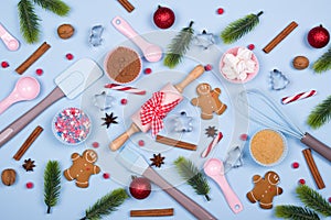 Christmas spices, cookie cutters, ingredients for christmas baking and kitchen utensils gingerbread cookies on blue pastel backgro