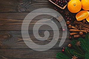 Christmas spices for drinks and cooking on dark wooden background, top view