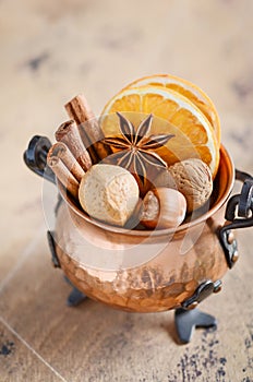 Christmas spices, nuts and dried oranges on a wooden background.