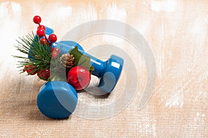 Christmas sport composition with dumbbells, berries and spruce