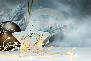 Christmas star and glowing garland lights against blurred silver