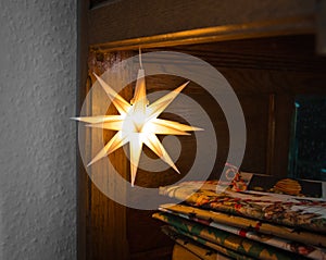A christmas star lightended in front of many gifts photo