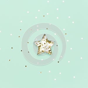 Christmas star made with mold for the cookies and gold sparkling stars on blue background. Flat lay. Holidays and Christmas