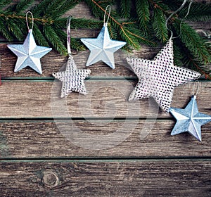 Christmas stars on wooden background with fir tree branches