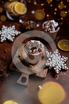 Christmas still life: cups with marshmallows and gingerbread on a brown background