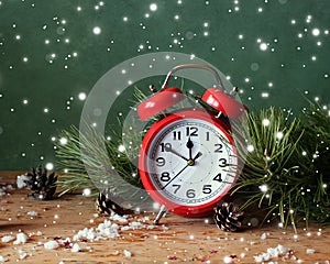 Christmas still life with red alarm clock and pine branches.