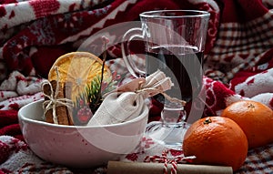 Christmas still life. Transparent glass beaker with red drink, white ceramic bowl with canvas small pouch