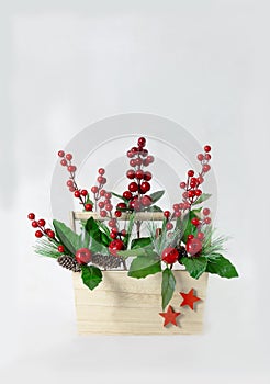 Christmas Still Life. Wooden basket with holly branches inside