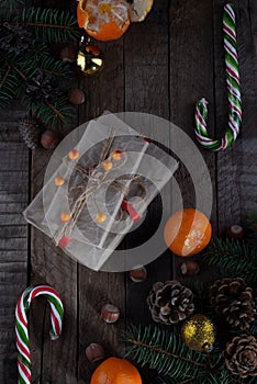 Christmas still life on a wooden table with gifts and New Year& x27;s candies, Christmas cones and fir trees