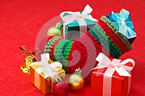 Christmas stocking and colorful presents on red fa