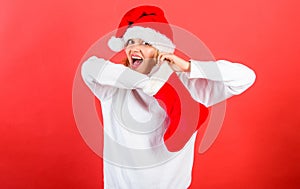 Christmas stocking concept. Girl cheerful face check out gift in christmas sock. Woman in santa hat unpacking christmas