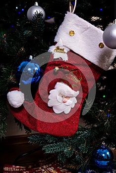 Christmas stocking. Red sock with snowflakes for Santa\'s gifts hanging on the Christmas tree. Winter holidays