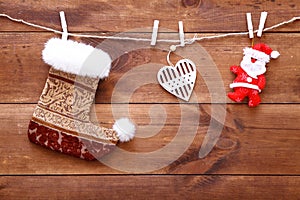 Christmas stocking, santa and heart hanging on brown wooden background, decorative xmas toys on wood table, buying presents shoppi