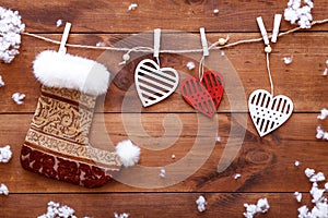 Christmas stocking, white red hearts hanging on brown wooden background, xmas valentines day card, copy space, top view