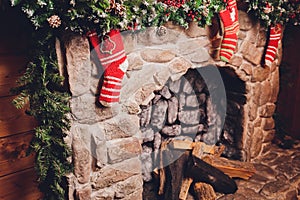 Christmas stockings hanging over a fireplace with candles on the mantlepiece.