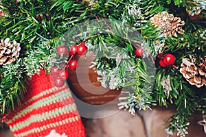 Christmas stockings hanging over a fireplace with candles on the mantlepiece.