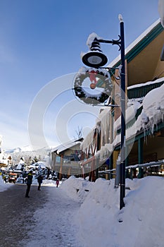 A Christmas Story in the Village of Whistler. Snowy buildings - on the roofs, ski resort. A cold but clear sunny winter day.