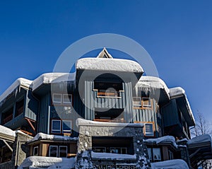A Christmas Story in Whistler  village - Snow-covered buildings - on the roofs, Ski resort. A cold but clear sunny winter day.