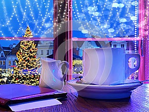 Christmas street restaurant  evening in the city blurred light Tallinn old  town square green tree illuminated table  top cup with