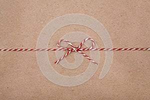Christmas string or twine tied in a bow on kraft paper background