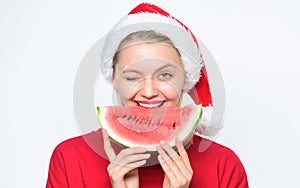 Christmas summer destinations. Christmas girl eat watermelon. Woman santa hat hold slice watermelon. Prolong summer photo