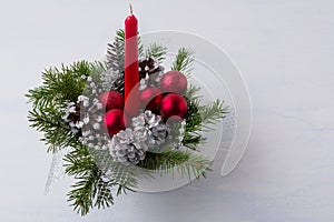 Christmas table centerpiece with red candle and silver pine cone