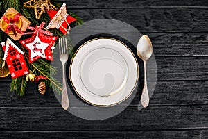 Christmas table decoration. Christmas dinner plate, cutlery decorated festive decorations. Winter holidays. Christmas card.