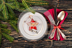 Christmas table decoration. Christmas dinner plate, cutlery decorated festive decorations. Winter holidays. Christmas card.