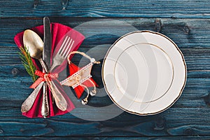 Christmas table decoration. Christmas dinner plate, cutlery decorated festive decorations. Winter holidays. Christmas card.