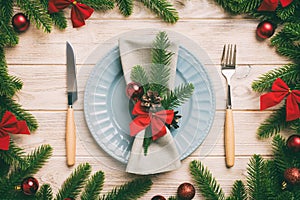 Christmas table place setting with christmas decor and plates, kine, fork and spoon. Christmas holiday background. Top