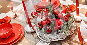 Christmas table place setting with christmas pine branches, cones, decorations with blurred, sparking, glowing.